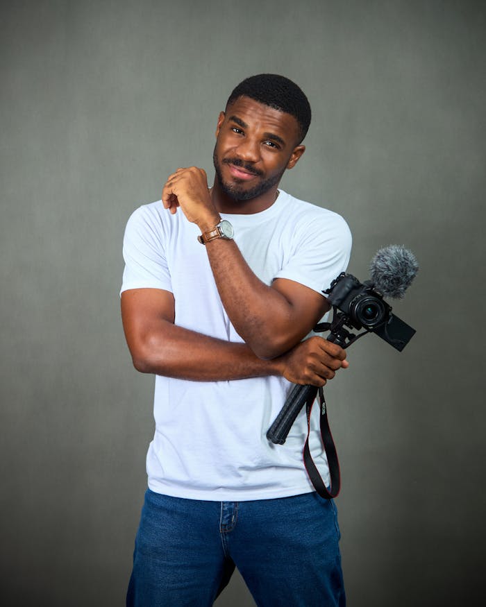 Portrait of a confident African man holding a camera, ready for filming.